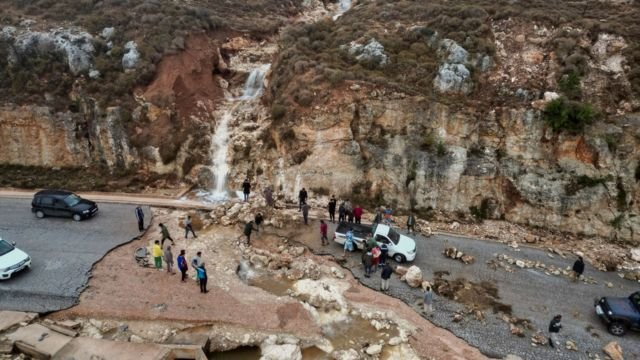 Personas en una carretera afectada por las lluvias en Libia.